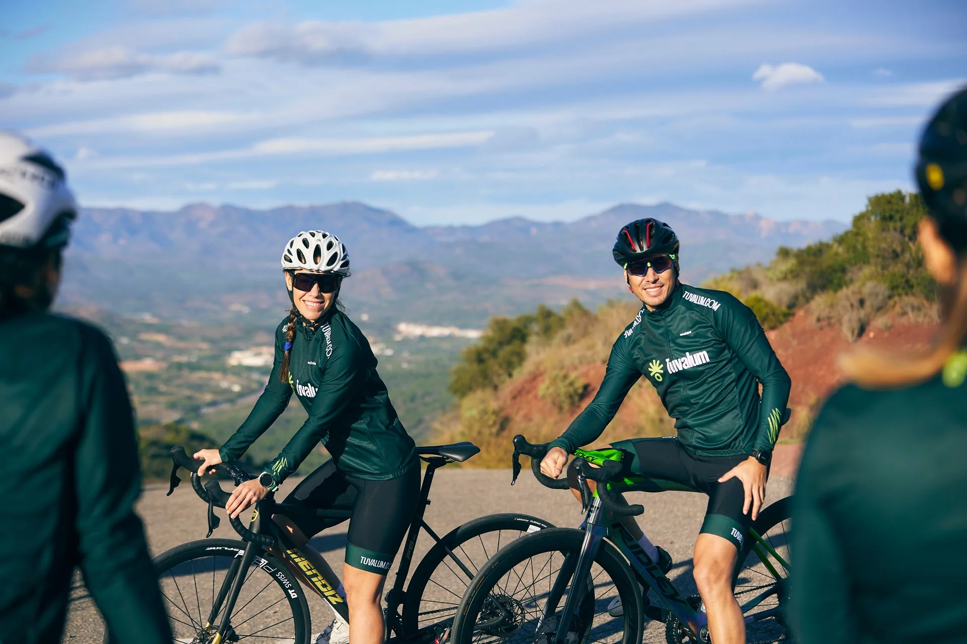 Ciclistas, incluida una mujer y un hombre, entrenando juntos en una carretera de montaña